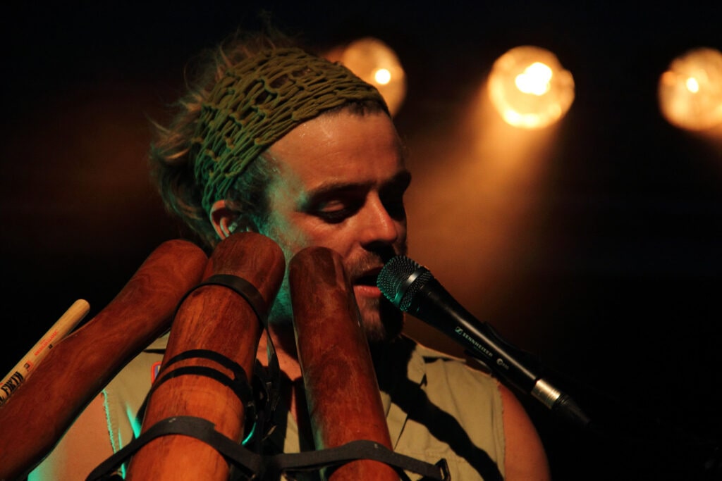 Xavier Rudd nel concerto al Carroponte. 2010. Xavier, polistrumentista che suona circondato da tre didgerodoo, chitarra e percussioni, è un significativo esponente della world music australiana.